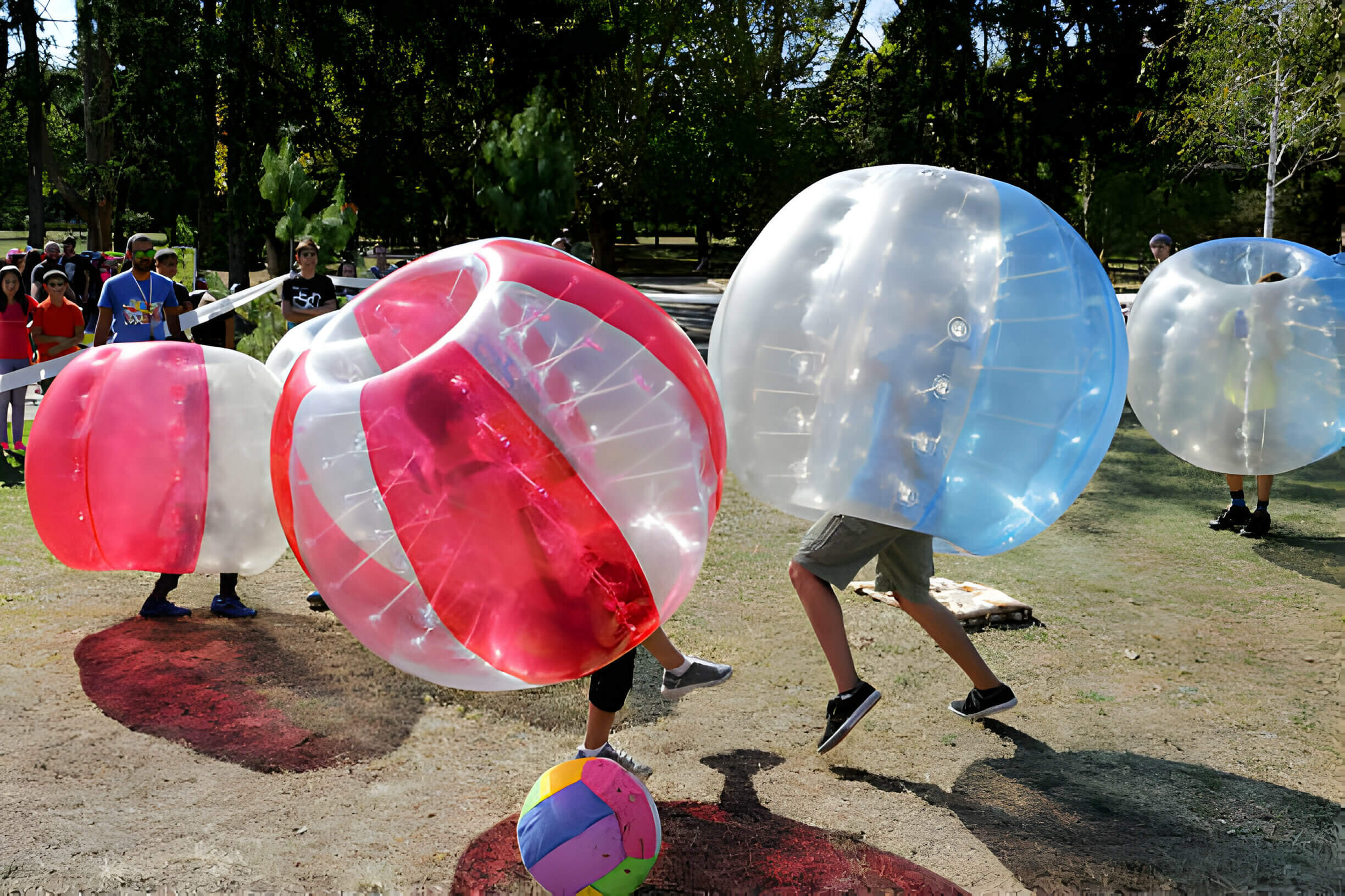 Friends and Family playing zorb / inflatable bubble soccer